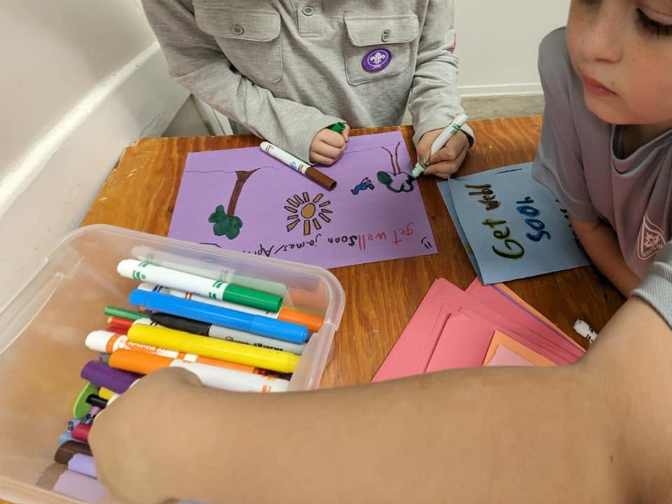 Scouts making colourful posters during a meeting